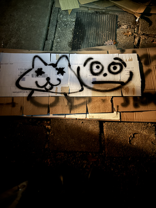 graffiti doodle of two faces on cardboard