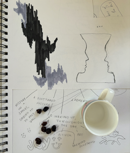 sketchbook page with L's handwriting on it and raisins scattered on top